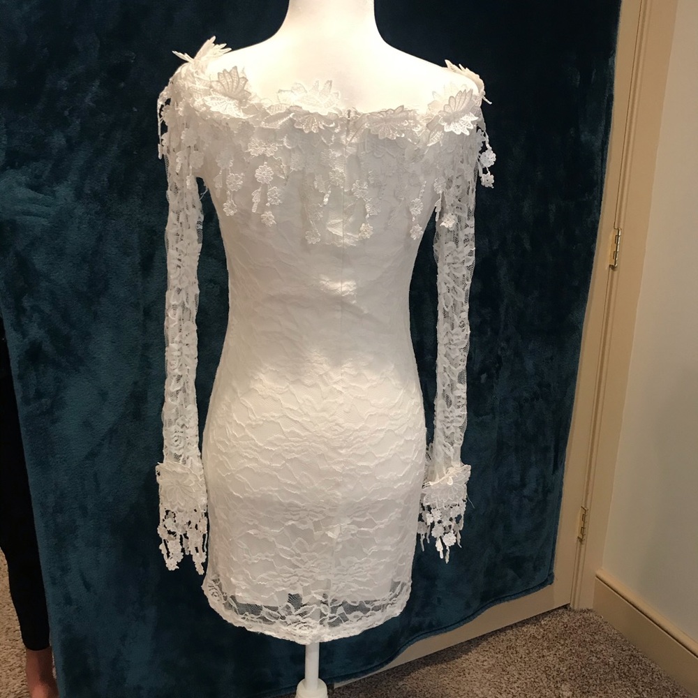Long sleeved white lined dress with flower detail